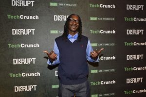 man in front of printed step and repeat